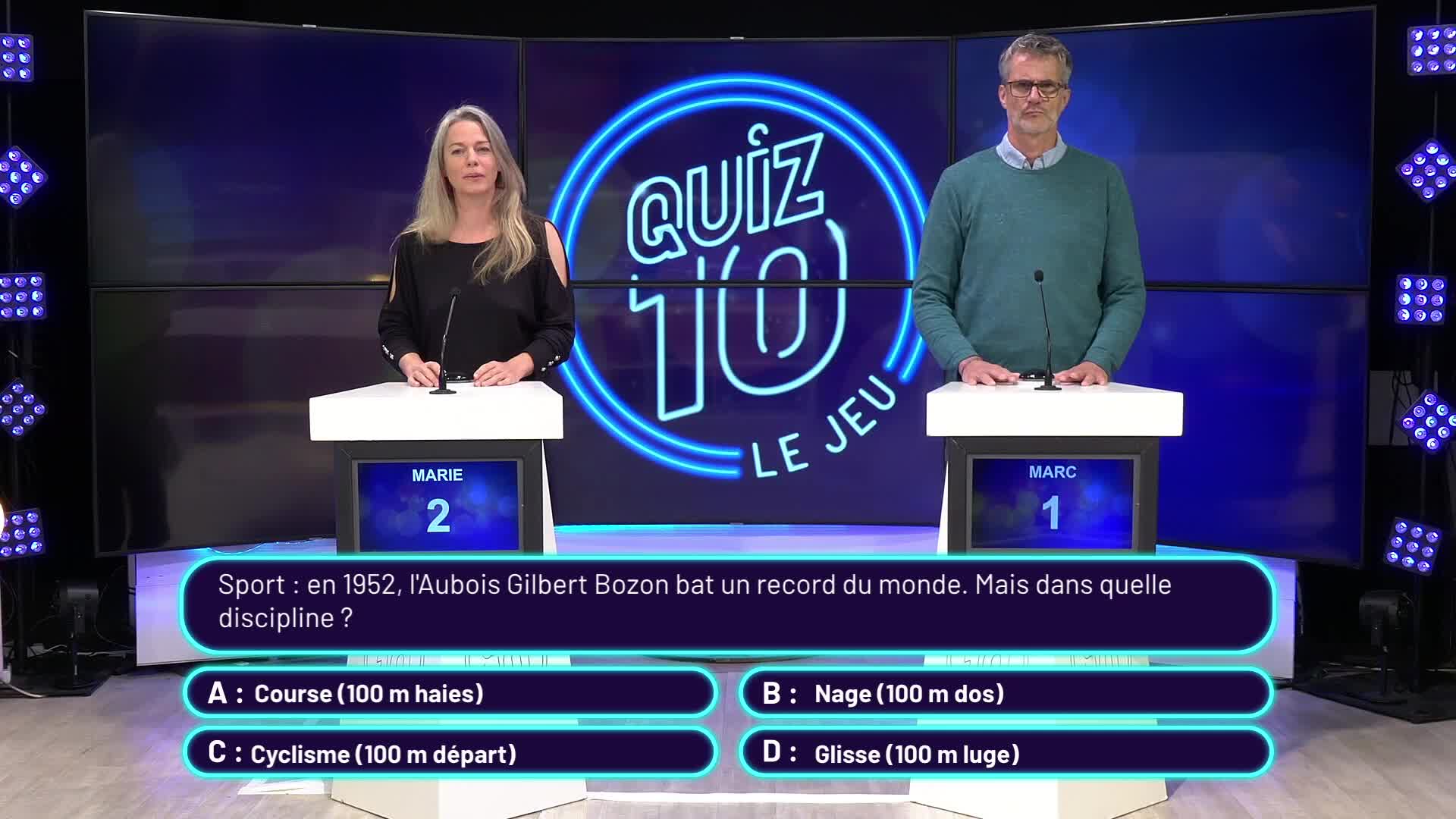Deux candidats debout face à leurs pupitres sur le plateau du jeu Quiz 10 avec le logo lumineux en arrière-plan